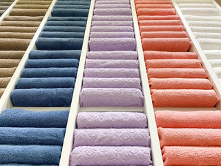 many colorful towels is folding in shelfs at store for Sales .  - 373424701