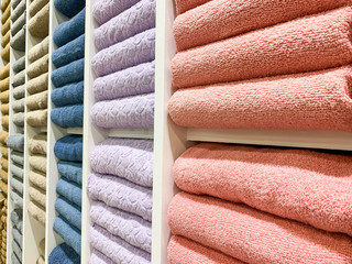 many colorful towels is folding in shelfs at store for Sales .  - 373424744