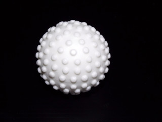 White massage ball on a black background.