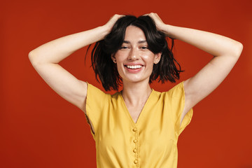 Image of young cheerful woman smiling and grabbing her head