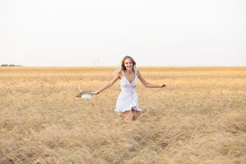 Fototapeta na wymiar Laughing young woman in a wheat field
