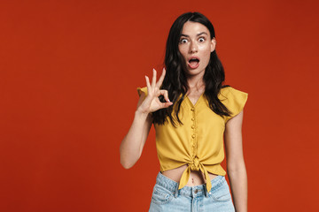 Image of nice shocked woman showing ok gesture on camera