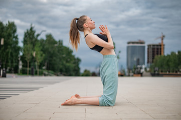 Girl practice yoga and meditation in the city.