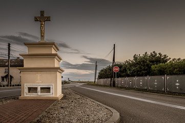 murowana kapliczka z krzyżem przy szosie