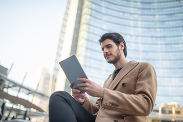 Young man using his tablet outdoor