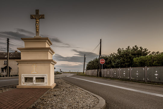 murowana kapliczka z krzyżem przy szosie