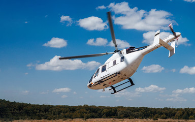A white helicopter takes off from the runway