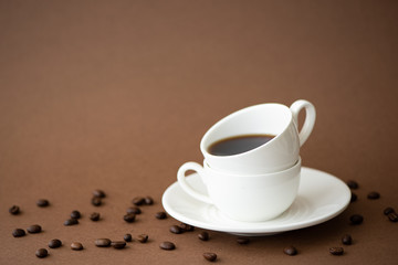black coffee in coffee cups on brown background