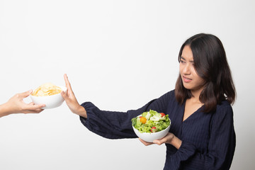 Young Asian woman with salad say no to potato chips.
