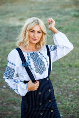 Blonde European girl in traditional Romanian folk costume with embroidery. Romanian folklore.