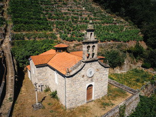 Aerial view of church in vineyard on a hill. Belesar in Ribeira Sacra, Ourense, Spain