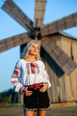 Blonde European girl in traditional Romanian folk costume with embroidery. Romanian folklore.