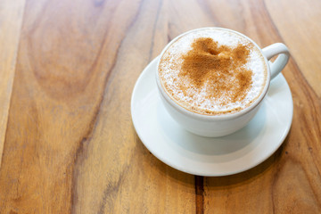 Coffee with cinnamon close-up on wooden background, copy space