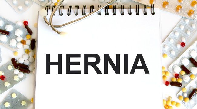 HERNIA - inscription in a notebook, next to a tablet and a stethoscope. A medical concept.