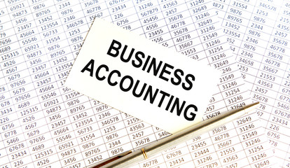 Obraz premium Finance and business concept. The businessman has on his desk graphs with reports, a notebook, a magnifying glass and a document with the inscription - BUSINESS ACCOUNTING