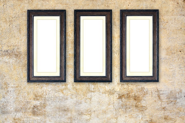 Fototapeta na wymiar Three empty picture frames on old stucco wall