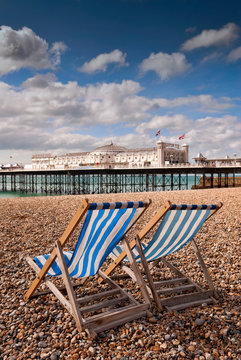 Brighton, England - September 11, 2009: Empty Deckchairs on Beach next to Brighton Pier, First opened in 1899