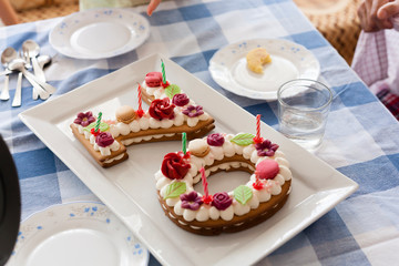 70th anniversary cake with candles and ornaments on a table. Grand father birthday concept