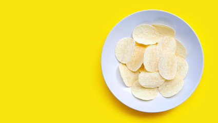 Potato chips on yellow background.