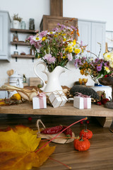 Autumn interior and still life. Pumpkins, apples, zucchini, autumn leaves and flowers. Background. Postcard. Flat lay.