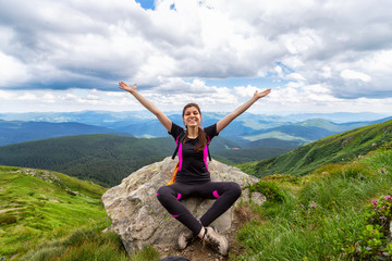 Happy young girl with raised hands on a background of beautiful mountains. Ukraine. Carpathians. Recreation.