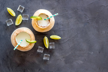 Green coconuts with drinking straw - tropical cocktail, above view