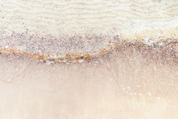 Top view Soft wave of the sea on the sandy beach with white clean foam.