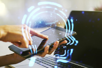 Creative artificial Intelligence concept with human head hologram and finger clicks on a digital tablet on background. Multiexposure