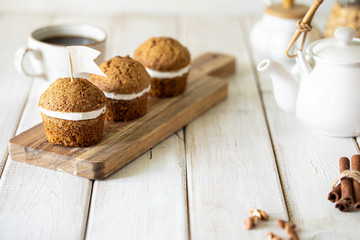 Carrot muffins with nuts and cream on a white plate. Vegan muffins. Traditional donkey pastries. Selective focus. Copy space.
