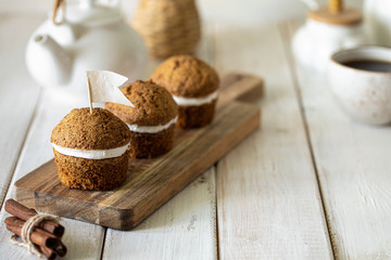 Carrot muffins with nuts and cream on a white plate. Vegan muffins. Traditional donkey pastries. Selective focus. Copy space.