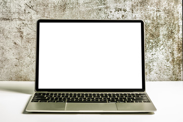 Fototapeta premium Modern laptop with mock up white screen for texting on white table and grunge background.