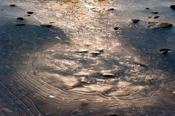 Natural texture ribbed melting thin crystal ice and misterious ice line on the stream.
