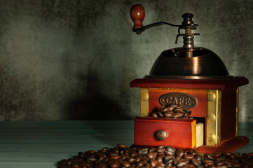 Vintage coffee grinder with coffe beans on table.