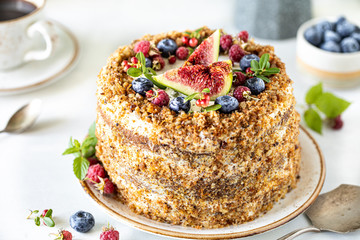 Carrot cake decorated with berries and figs on a white plate. Traditional donkey pastries