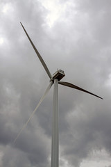 Wind turbine against a cloudy sky on a grey rainy day