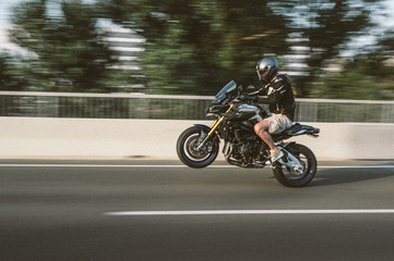 Obraz na płótnie Canvas Motorcyclist driving on the back wheel
