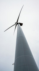 Wind turbine against a cloudy sky on a grey rainy day