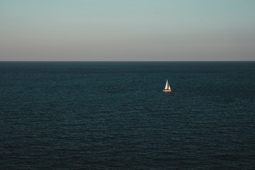 Sailboat on the ocean, blue sky, negative space