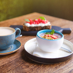 Fruit pudding and cappuccino coffee on a table in a summer restaurant, close up