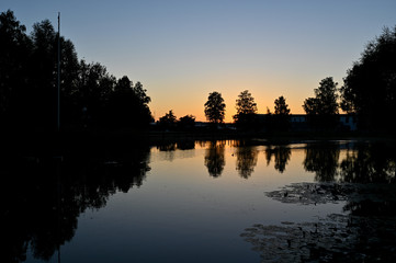 Obraz premium sunset over calm pond in silent park