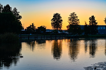 sunset over calm pond in silent park