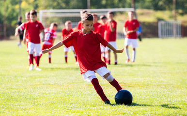 Obraz premium Young boy shooting soccer ball