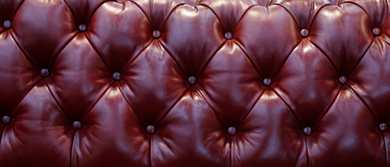 Vintage leather sofa button backrest of brown red cherry in texture. Wallpaper. for pattern and background.