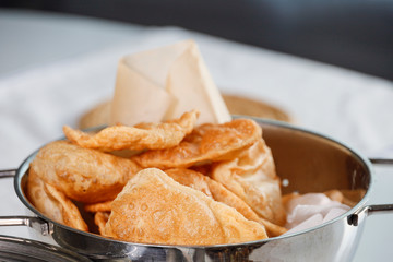 Fresh homemade Puri Indian bread drying in a colander.