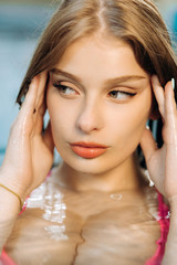 Portrait of a luxury girl. Pretty blonde in the pool.