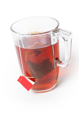 Glass cup of freshly brewed black tea with tea bag