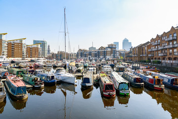 Boats and yachts moored at Limehouse Basin marina with Canary Wharf in the background in London
