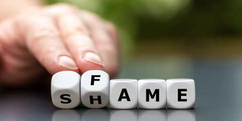 Hand turns dice and changes the word shame to fame.