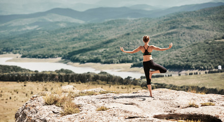 Yoga time. Stretching and Outdoors training. Female wearing sportswear. Balance position. Breathtaking view. Copy space