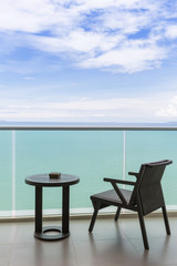 Table and chair with outdoor balcony and sea .The chair and table on balcony sea view. Chair with table set on balcony hotel room with ocean view background.